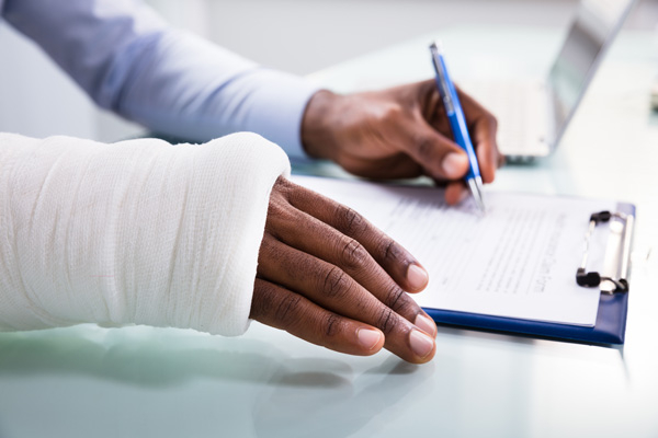 man with cast completing workers compensation form